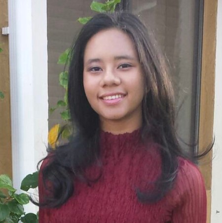 Headshot of a young woman with long, dark hair and a burgundy sweater